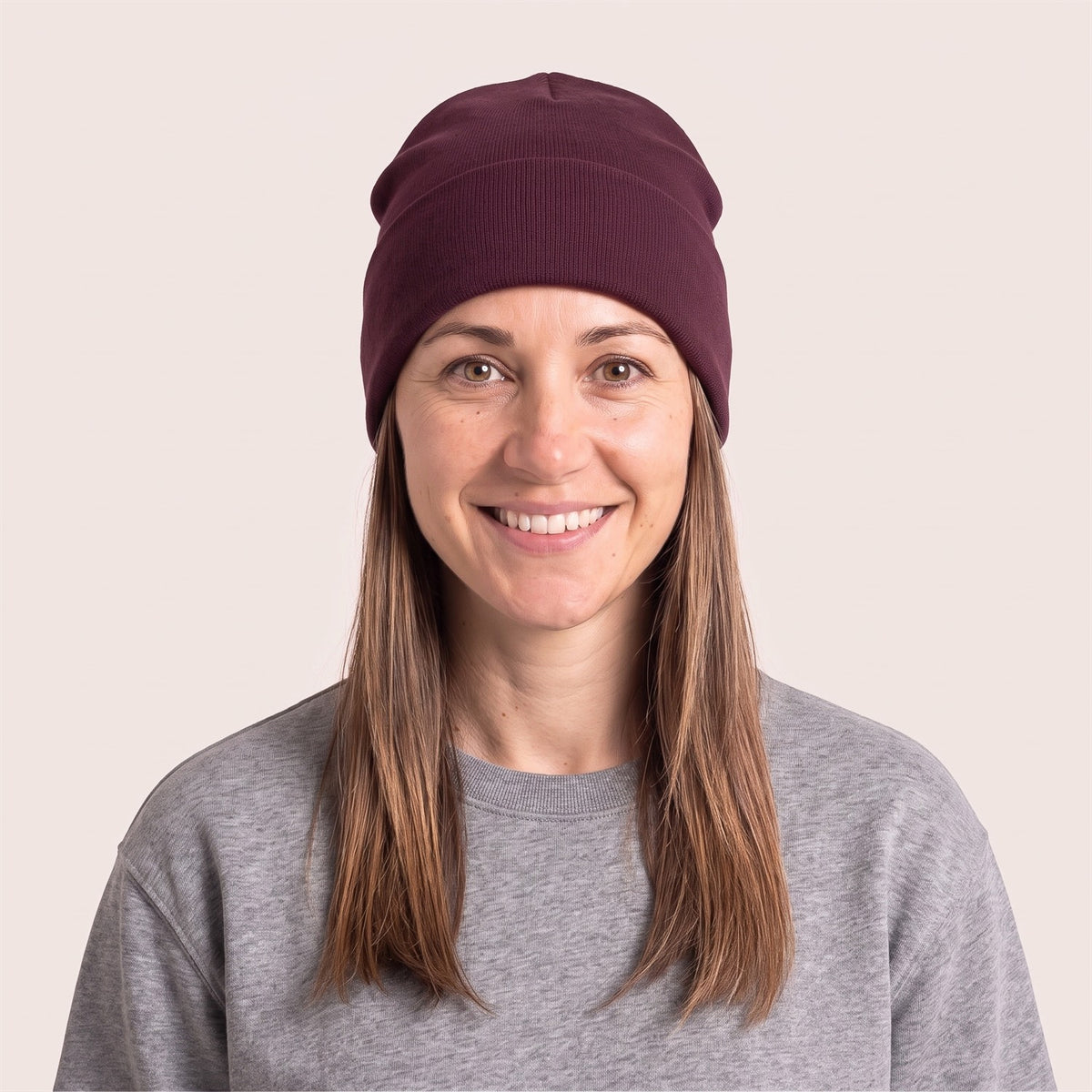 Unisex Beanie aus Bio-Baumwolle in Deep Plum – Vorderansicht an der Frau (AI-modifiziert)