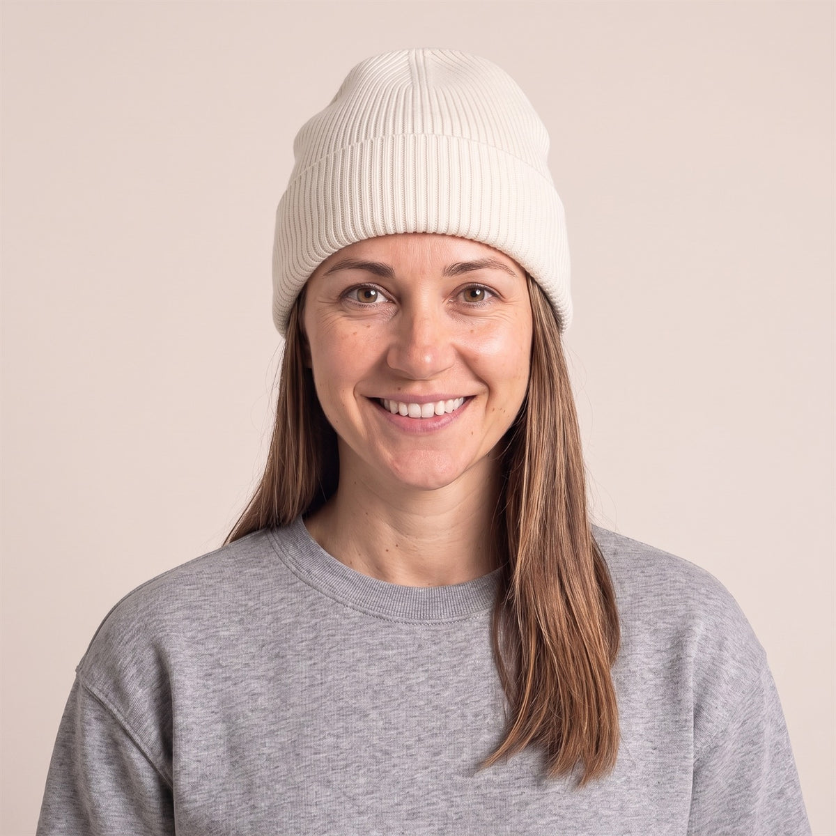 Unisex Docker Beanie im Rippstrick in Natural – Vorderansicht an der Frau (AI-modifiziert)