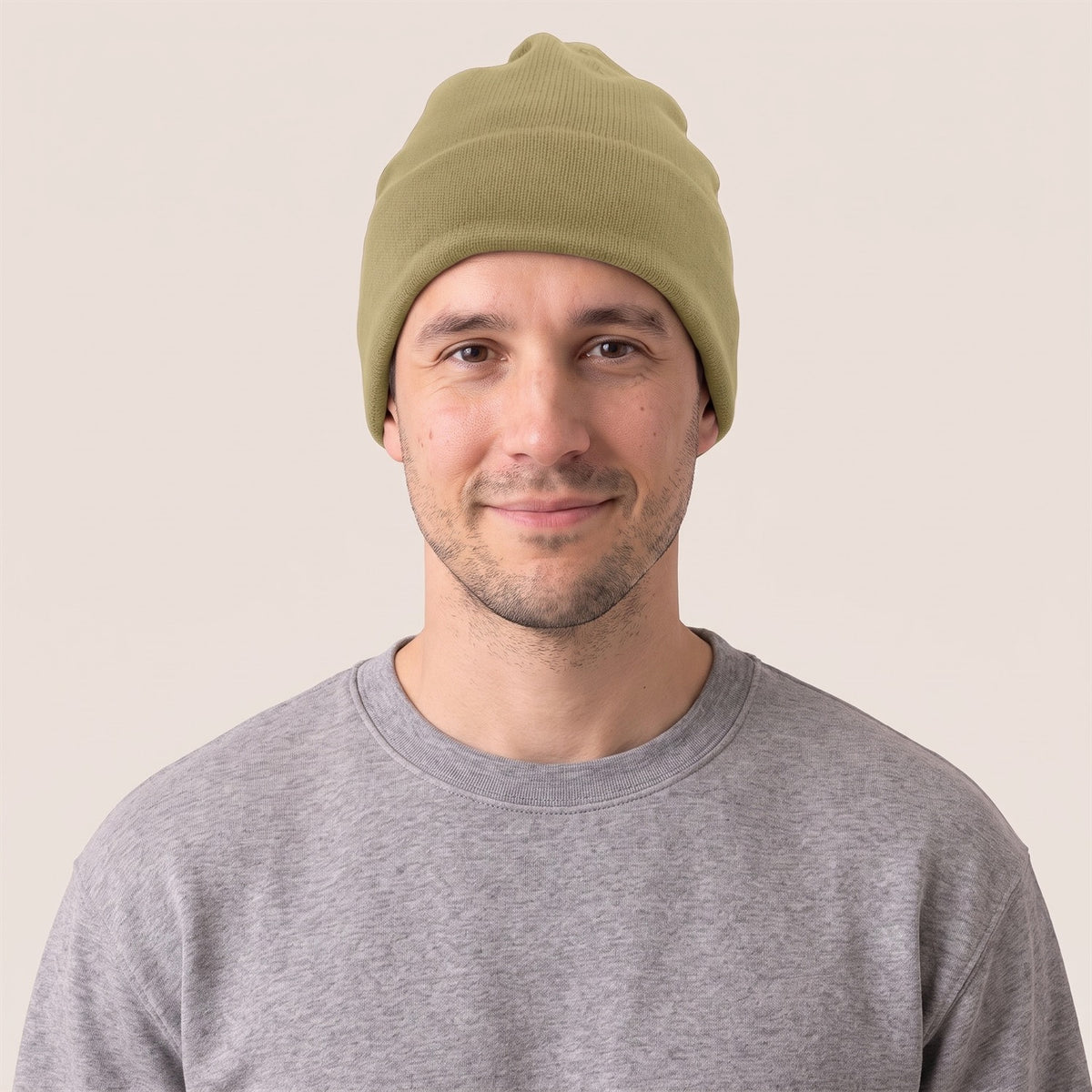 Unisex Beanie aus Bio-Baumwolle in Faded Olive – Vorderansicht am Mann (AI-modifiziert)