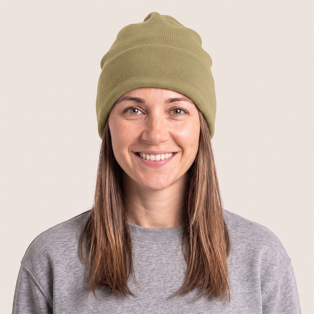 Unisex Beanie aus Bio-Baumwolle in Faded Olive – Vorderansicht an der Frau (AI-modifiziert)