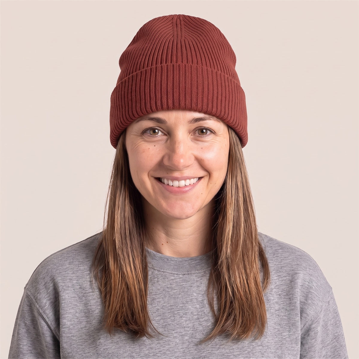 Unisex Docker Beanie im Rippstrick in Earthy Red – Vorderansicht an der Frau (AI-modifiziert)