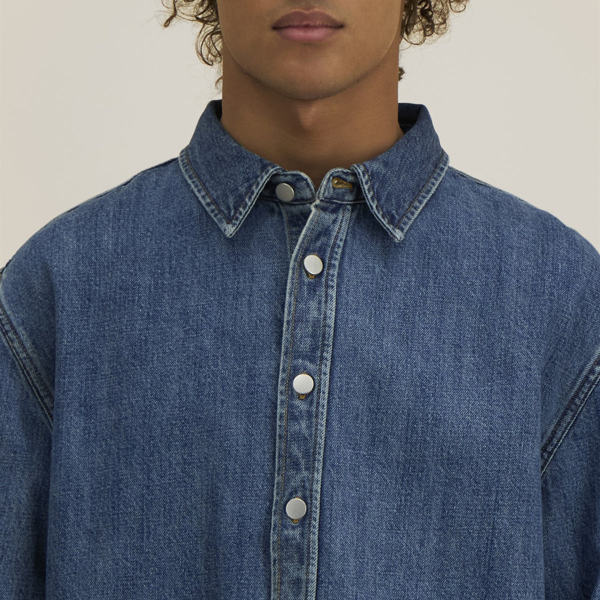 Detail: Kragen und Metallknöpfe des Denim Overshirts in Mid Wash