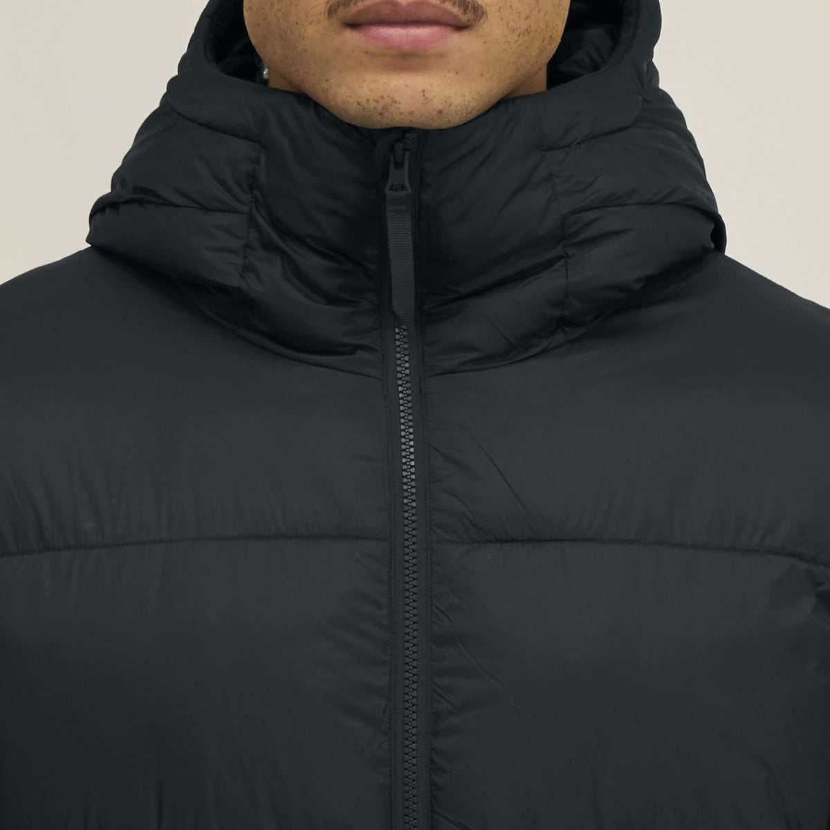 Detail: Kragen und Reißverschluss der Pufferjacke in Schwarz