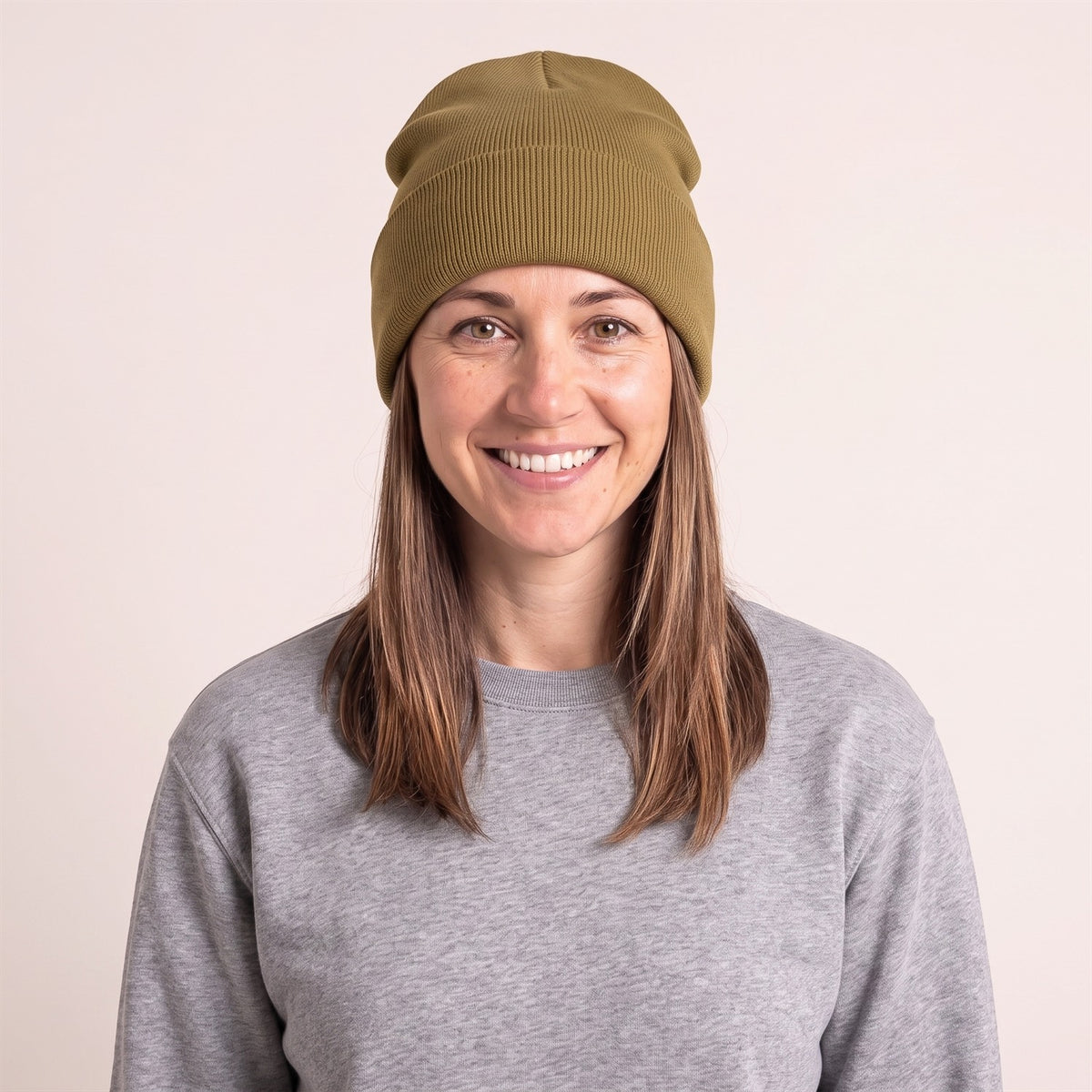 Unisex Beanie mit Umschlag im Feinripp in Bronze – Vorderansicht an der Frau (AI-modifiziert)