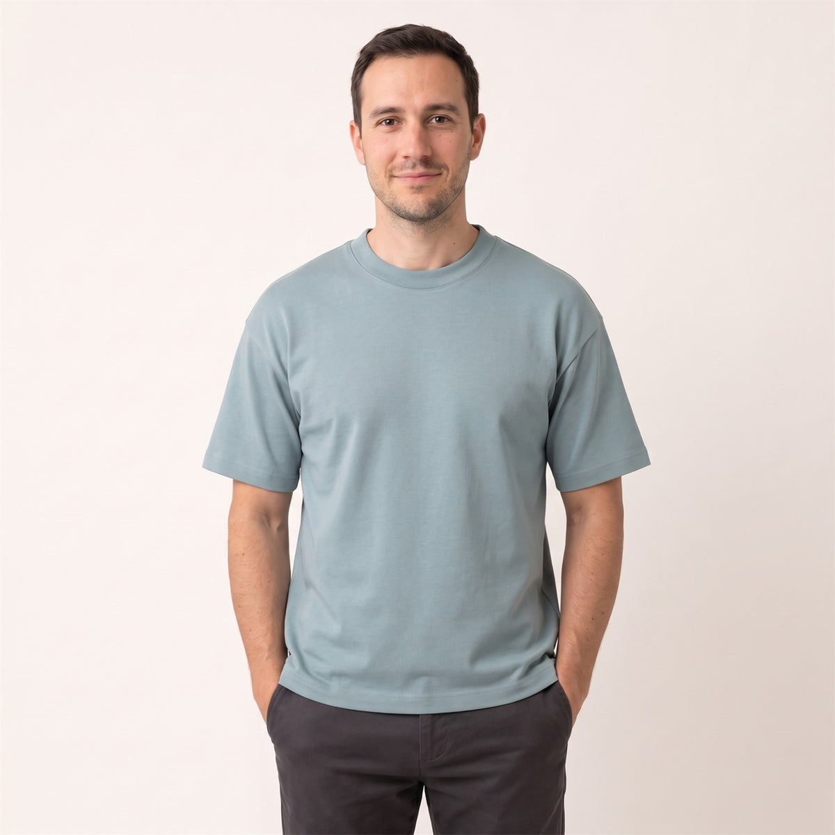 Ultra Heavy Unisex T-Shirt in Pebble Blue – Vorderansicht am Mann (AI-modifiziert)