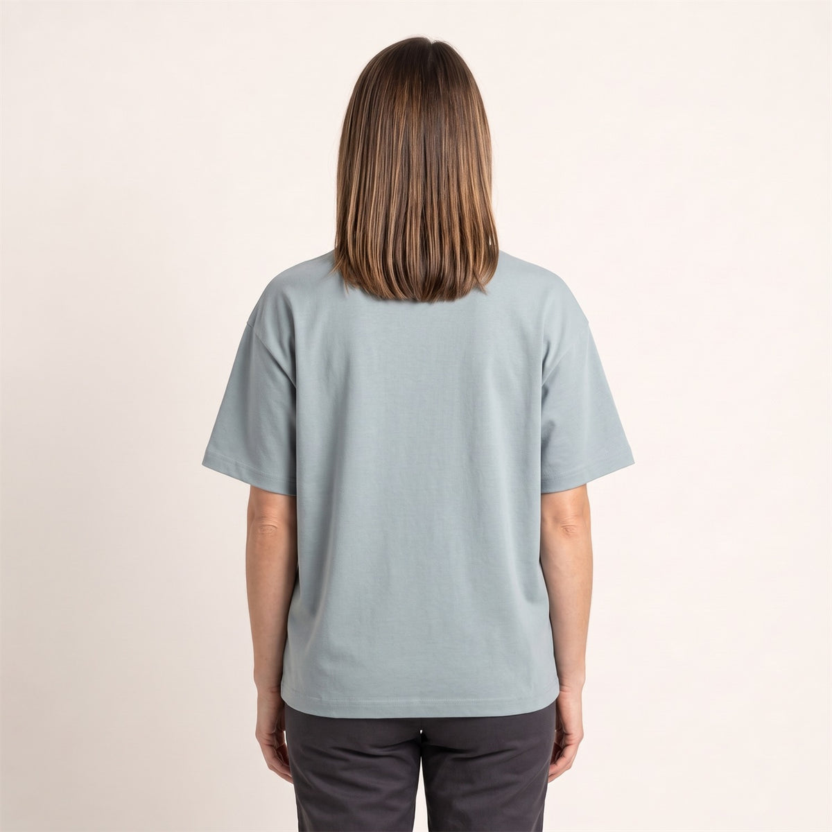 Ultra Heavy Unisex T-Shirt in Pebble Blue – Rückansicht an der Frau (AI-modifiziert)